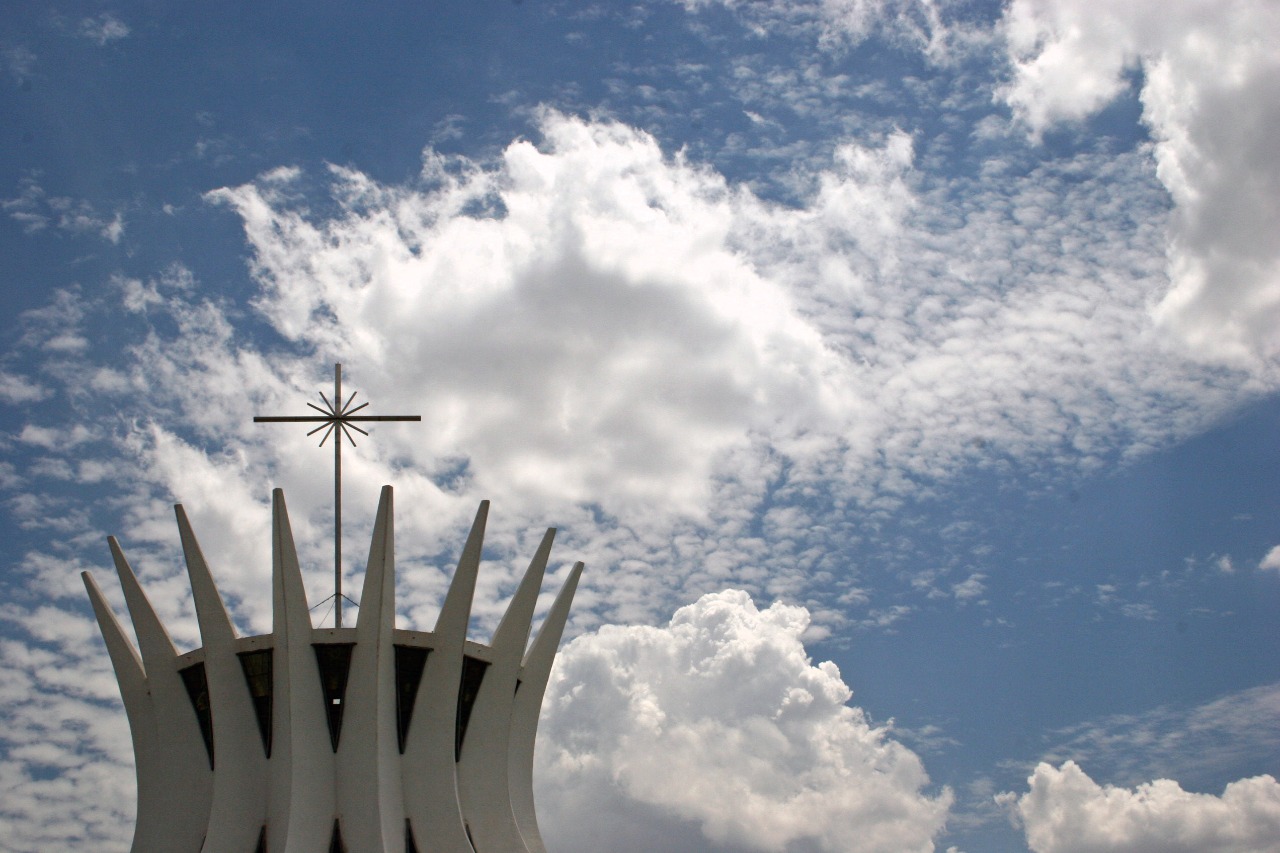 Foto da Catedral de Brasília com um céu cheio de nuvens ao fundo